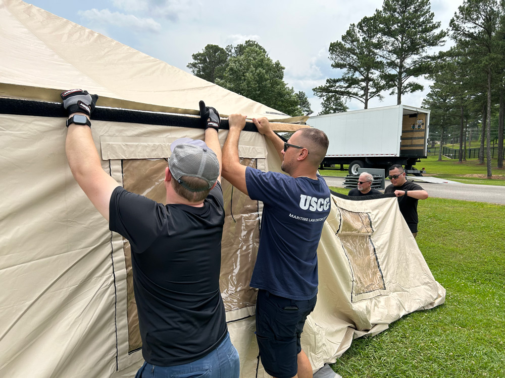 Two members of an incident management assistance team set up a tent shelter.