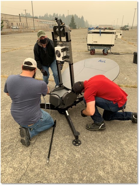 3 people setting up a communications tower 