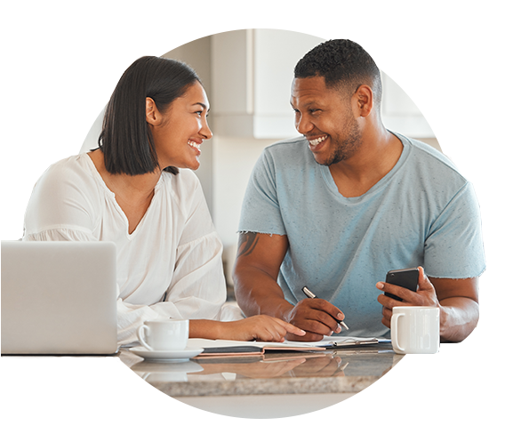 Man and woman smiling and sitting at a table doing paperwork