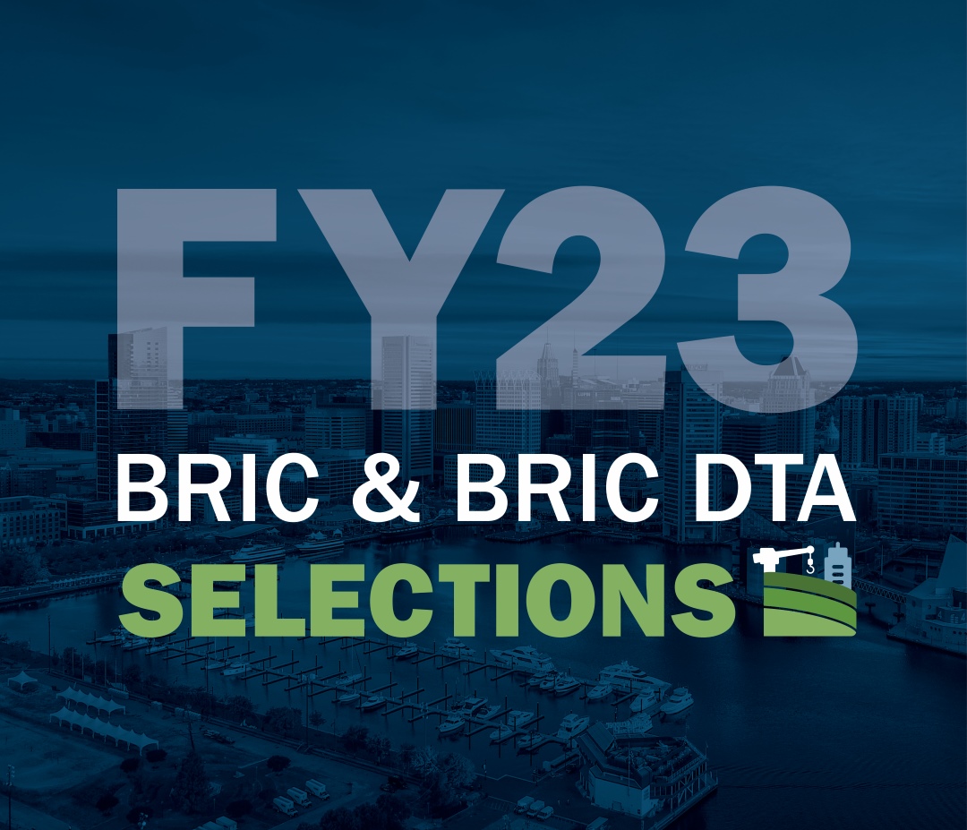 Words over a photo. The photo is of a marina area, with skyscrapers in the background. The words read "FY23 BRIC and BRIC DTA Selections"