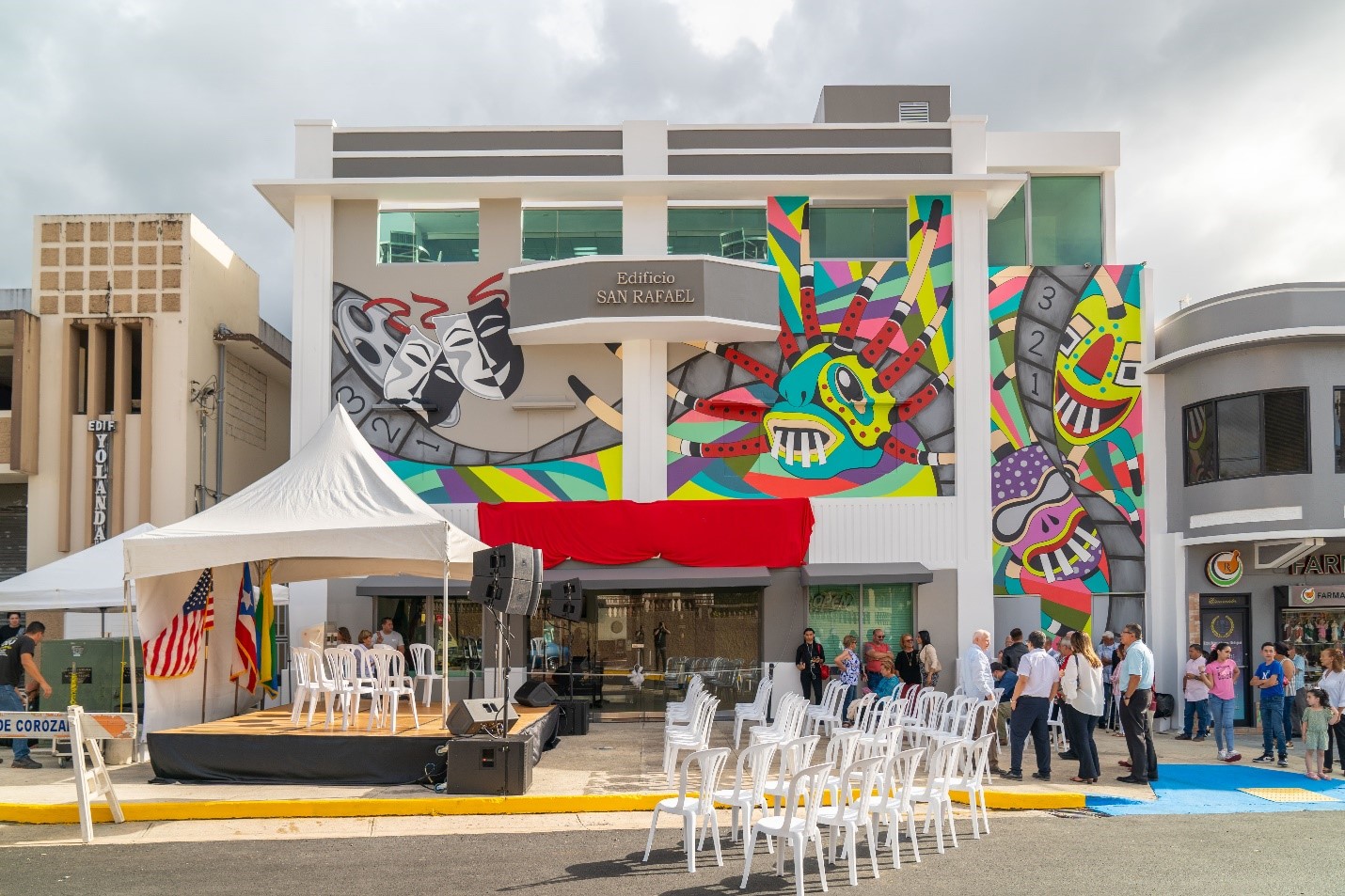 Front view of movie theater. In the front wall painting of colorful "Vegigantes"" In front the building a tent 