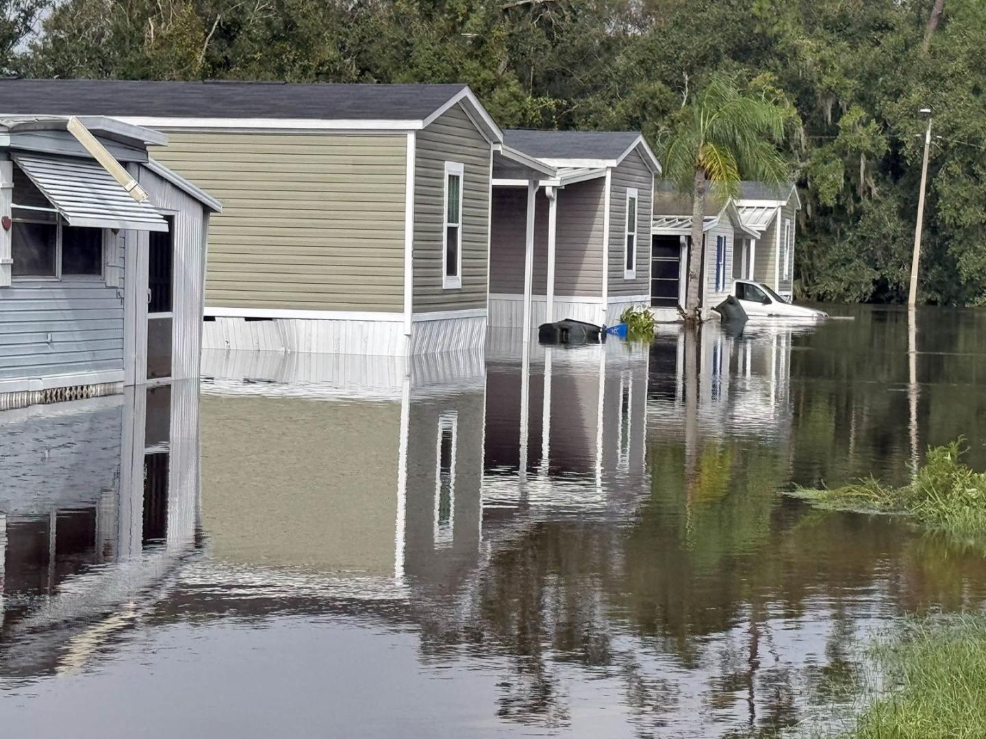 Standing water floods a row of mobile homes