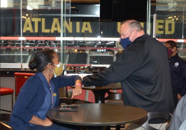 FEMA External Affairs Site Lead Shelli Holmes fist-bump greets Acting FEMA Administrator Bob Fenton inside the Mercedes-Benz Stadium community vaccination center.