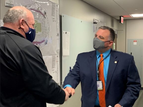 Acting FEMA Administrator Bob Fenton fist-bump greets Matthew Kallmyer of Fulton County Emergency Management Services during his visit to the newly expanded community vaccination center at Mercedes-Benz Stadium.