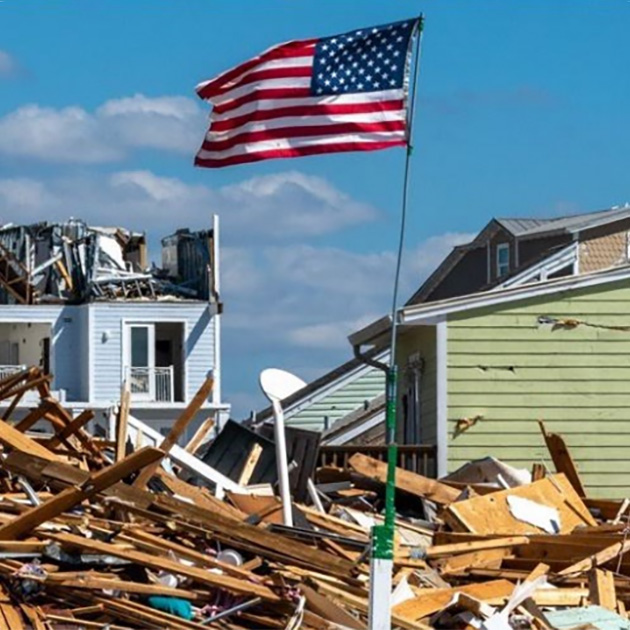 American flag amid destroyed homes