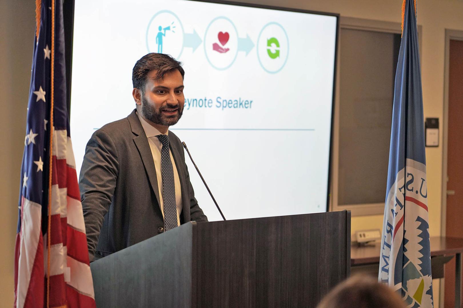 A man speaks from behind a podium. 