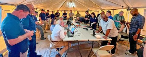 Caption: <p>St. Croix, U.S. Virgin Islands, May 23, 2024 -- FEMA's Region 2 Incident Management Assistance Team with regional leadership, along with elements of Region 2's Response and Recovery divisions and the New Jersey All-Hazards Incident Management Team collaborate May 23 in a field tent set up by IMAT and Virgin Islands Recovery Office logistics during a hurricane readiness exercise outside the Virgin Islands Territorial Emergency Management Agency's Emergency Operations Center on St. Croix. FEMA/Kirk Henderson</p>