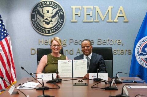 Image with caption: WASHINGTON – La administradora Deanne Criswell de FEMA (a la izquierda) y el fundador y director ejecutivo de Operación HOPE, John Hope Bryant, (ta la derecha) sostienen el acuerdo firmado. (Foto de FEMA).