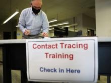 masked man at contact tracing training check-in table