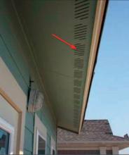 Fiber cement soffit with ventilation slots (red arrow)