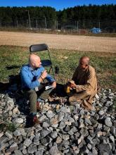 Ricardo sitting on rocks interviewing someone 